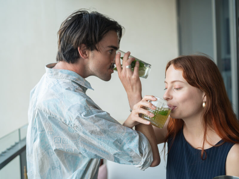 A couple link arms and take sips from their DIY cocktails.
